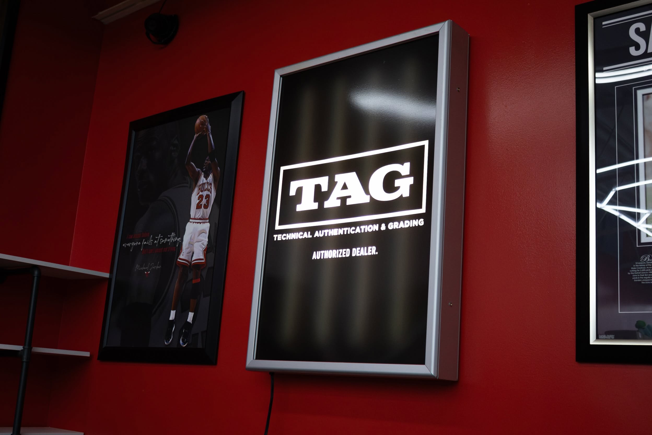 Illuminated TAG authorized dealer sign on the red wall inside Elite 4